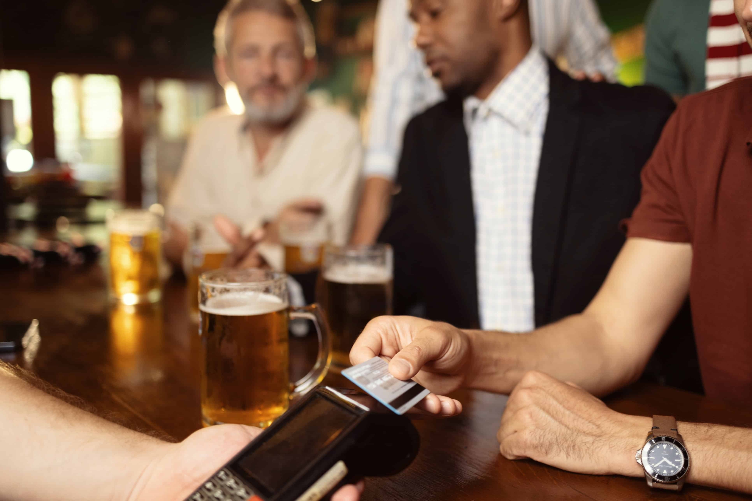 man paying for drink at bar